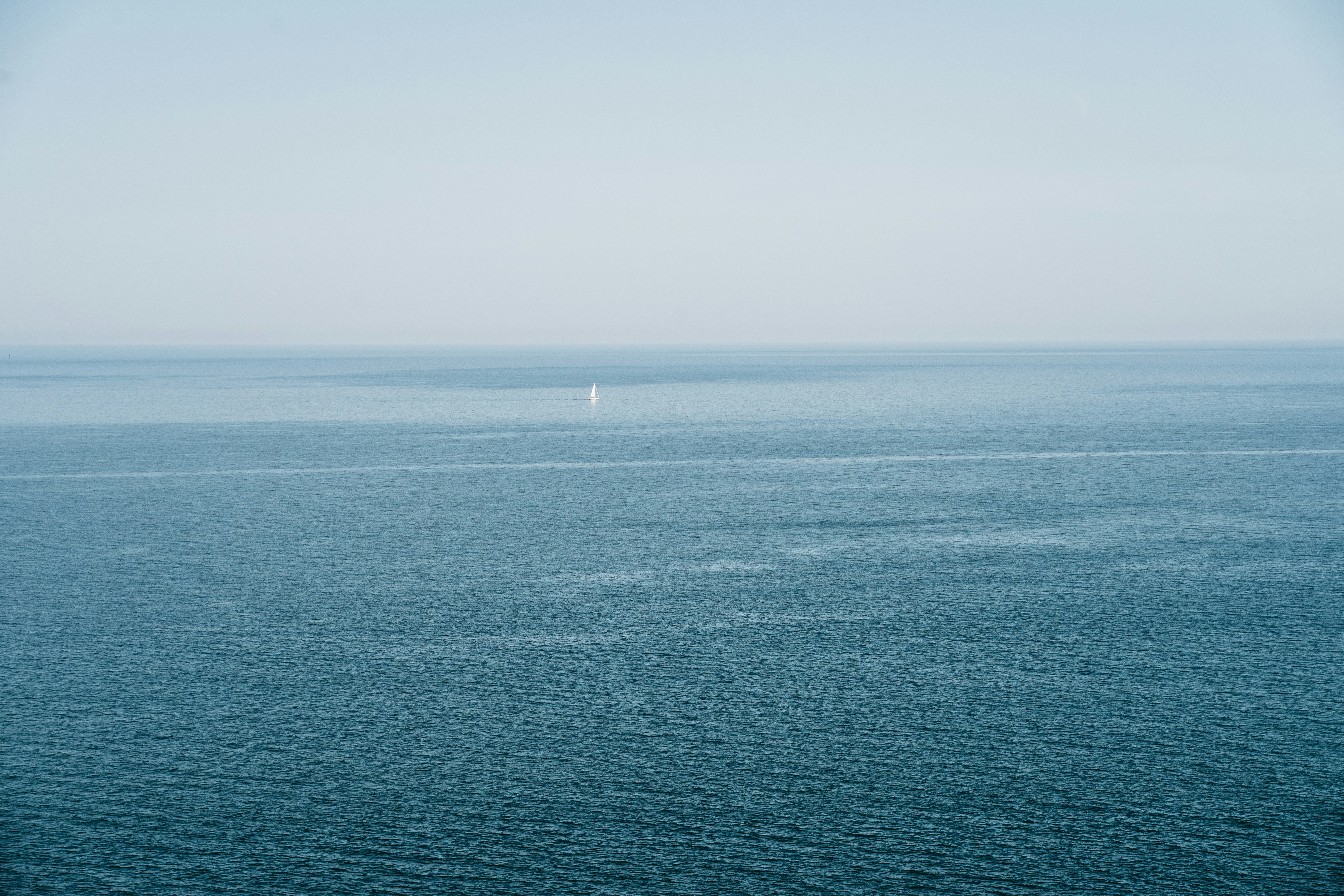 body of water under white sky during daytime